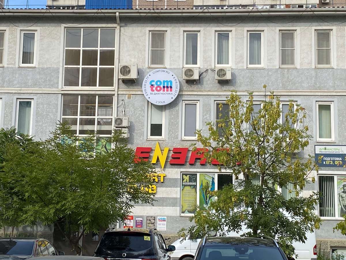 Фасад здания на Платановом бульваре, 19/3, с круглой вывеской COMTOM на втором этаже